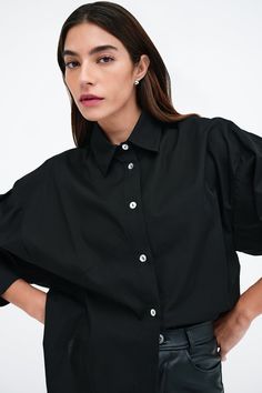 Our Ezra Shirt is a capsule wardrobe dream for your closet. Crafted from 100% crisp European poplin cotton, she offers a classic button-up silhouette in front, but with a cropped back for modern edge. Say hello, as well, to her diagonal seams at the front, sleek collar and long dolman sleeves finished with mother-of-pearl button cuffs. Wear Ezra tucked, tied or open and free—she never fails to inspire new looks.[SPLIT] Rocio, in black and in light blue, is 5'9.5" (175 cm) tall, wearing size XS. Women In White, Tunic Hoodie, Character Board, Fashion Now, Simple Wallpapers, New Looks, Summer Clothing, Black Xs, Mother Of Pearl Buttons