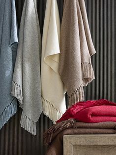 several towels hanging on a wall next to a bed with a wooden headboard and foot board