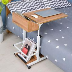 a bed with a laptop on top of it next to a plant and flower pot