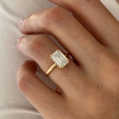 a woman's hand with a diamond ring on top of her finger and an engagement band