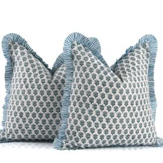 two blue and white pillows with ruffled edges