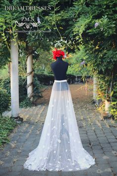 the back of a woman's wedding dress with flowers in her hair and veil