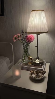 a table with a lamp and some flowers on it