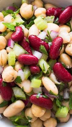 a bowl filled with beans, celery and other vegetables on top of a table