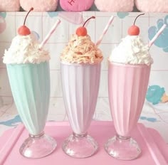 three ice cream sundaes with cherries on top