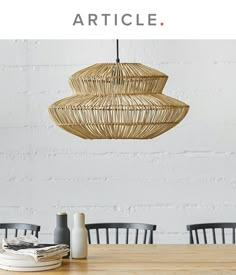 a table with chairs and a basket hanging from the ceiling over it that says article