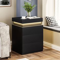 a black night stand with a plant in it and a clock on the wall behind it