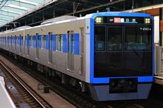 a blue and white train pulling into the station