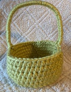 a green basket sitting on top of a bed