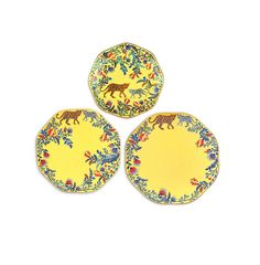 three yellow plates with animals on them sitting next to each other in front of a white background