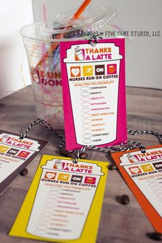 a table topped with lots of cards next to a cup filled with drinks and candy