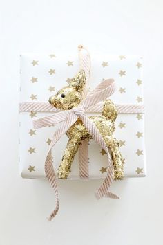 a present wrapped in white paper with gold stars on it