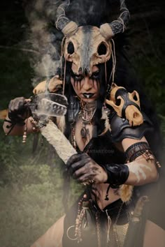 a woman with horns and makeup is holding a guitar in her hands while wearing an elaborate costume