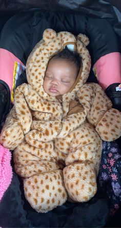 a baby sleeping in a teddy bear costume