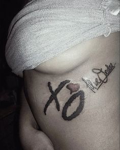 a woman's stomach with the word xo tattooed on her belly and an xo tattoo