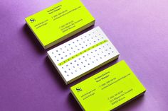 two business cards sitting next to each other on top of a purple surface with white dots