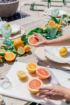 the table is set with grapefruits, lemons and other citrus fruits