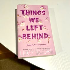 a pink book sitting on top of a white table next to a black and white cat