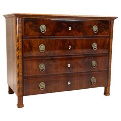 an antique chest of drawers with brass pulls and knobs on the front, against a white background