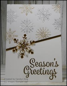 a white card with gold snowflakes and the words season's greetings on it