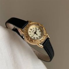 This elegant round watch features a durable and stylish black genuine leather strap, offering both comfort and longevity.The white dial is adorned with intricate engraved detailing around the edges, adding a touch of refined craftsmanship to its design. Small yet exquisite, this watch is perfect for everyday wear and effortlessly complements any outfit. Black And Gold Watch Women, Leather Watch For Women, Mini Gold Watch, Small Watches Women Vintage, Small Watches Women, Leather Band Watches, Classic Watch Women, Watches Women Black, Black And Gold Watch