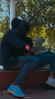 two people sitting on a bench with their arms around each other