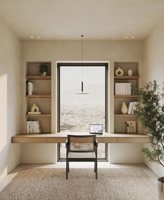 a room with a desk, shelves and a chair in front of a large window