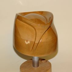 a wooden object is sitting on top of a wood stand with a heart above it