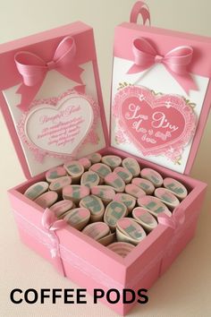 a pink box filled with lots of small wooden heart shaped cookies next to a card