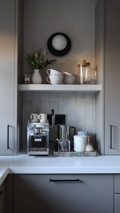 there is a coffee maker and cups on the shelf above the sink in this kitchen