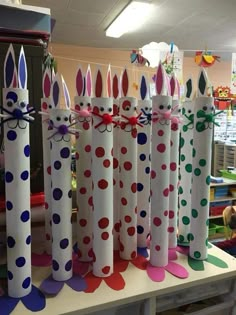 several paper tubes with bunny ears and polka dots on them, all lined up in rows