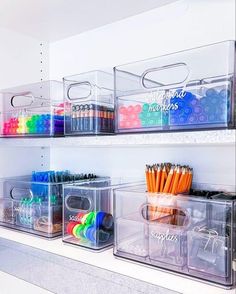 three clear bins filled with markers and pencils on top of a white shelf