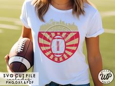 a woman holding a football and wearing a shirt that says svg cut file on it