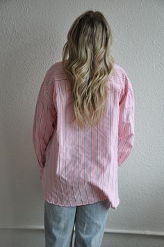 Introducing our Loose Fit Pink Striped Button Down, a stylish and versatile addition to your wardrobe. This button-down shirt features a relaxed, loose fit for ultimate comfort and ease of movement.Crafted from lightweight and breathable fabric, this shirt is perfect for both casual and dressy occasions. The pink stripes add a touch of femininity and sophistication, while the button-down design adds a classic and timeless appeal.The loose fit silhouette makes it easy to style and layer over your favorite tank tops or camisoles. Pair it with jeans or trousers for a chic and effortless look, or tuck it into a skirt for a more polished ensemble.Whether you're heading to the office, meeting friends for brunch, or enjoying a day out, our Loose Fit Pink Striped Button Down is sure to keep you lo Everyday Relaxed Fit Button-up Shirt, Striped Oversized Button-up Blouse, Oversized Striped Button-up Blouse, Pink Button-up Shirt For Day Out, Trendy Shirt With Relaxed Fit, Relaxed Long Sleeve Top With Button Closure, Effortless Everyday Shirt With Buttons, Trendy Relaxed Fit Shirt With Placket, Effortless Button Shirt For Everyday