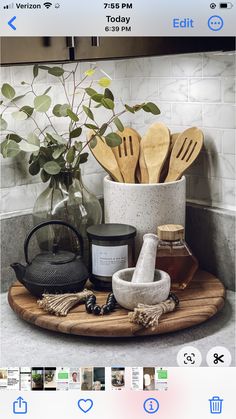 a wooden tray with utensils on top of it next to a potted plant