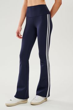 Front view of woman wearing dark blue high waist below ankle length legging with wide flared bottoms and white double side stripes on both legs. Paired with white shoes. Splits59 Flare Leggings, Tennis Outfit Ideas, College Wishlist, Apres Ski Outfits, Job Clothes, Walking Pad, Barre Pilates, Tennis Outfit, Flare Legging