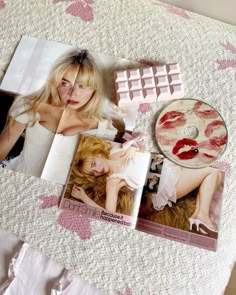 an open magazine with photos of women and lipstick on the pages next to a mirror