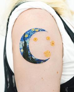 a woman with a tattoo on her arm has a crescent moon and stars painted on it