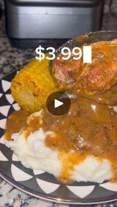 a plate topped with mashed potatoes and meat covered in gravy next to a crock pot