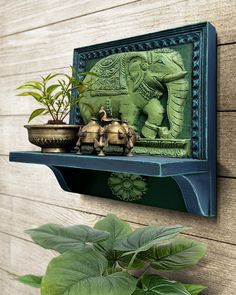 an elephant statue and potted plants on a shelf