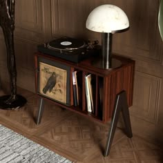 a record player sitting on top of a wooden table next to a lamp and bookshelf