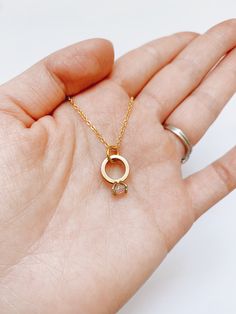 This very elegant engagement ring necklace is perfect for that special occasion. Simple and understated.  It looks great on its own or layered with other necklaces, and is the perfect everyday accessory. Item Details: Pendant: H: 10 mm L: 11 mm W: 1 mm Necklace clasp: lobster clasp. Materials: Pendant: 24k gold plated Chain: 14k gold plated, 17.5 inches or 19 inches Care Instructions: My jewelry carries powerful and positive vibrations.  Give it the care it deserves by avoiding contact with clea Dainty Round Pendant Charm Necklace For Anniversary, Dainty Charm Necklaces With Round Pendant For Anniversary, Dainty Charm Necklace With Round Pendant For Anniversary, Dainty Round Pendant Birthstone Necklace For Anniversary, 14k Gold Round Pendant Charm Necklace For Wedding, Gold Sterling Silver Solitaire Necklace For Wedding, Minimalist Charm Necklace With Birthstone For Anniversary, Minimalist Birthstone Charm Necklace For Anniversary, Minimalist Rose Gold Solitaire Necklace For Anniversary