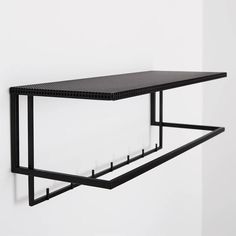 a black shelf is hanging on the wall