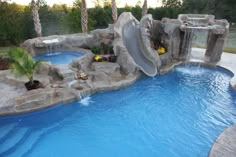 a pool with a slide and waterfall in the middle