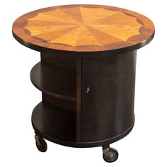 a wooden table with wheels on the bottom and an open drawer underneath it that has a circular design on top