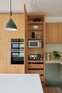 a kitchen with wooden cabinets and white counter tops, along with an oven and microwave