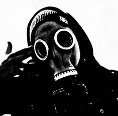 a man wearing a gas mask and holding his hands to his face