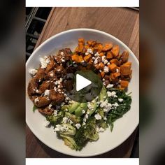 a white plate topped with broccoli and sweet potato salad next to a wooden table