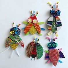 four colorfully decorated owls sitting on top of a white surface