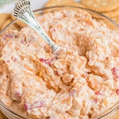 a bowl full of dip with crackers on the side